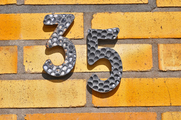 A house number plaque, showing the number thirty five (35)