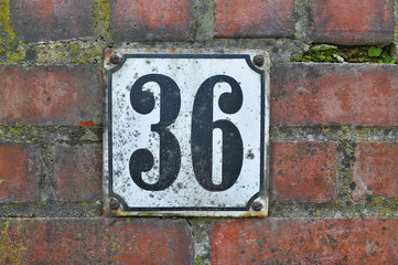 A house number plaque, showing the number thirty six (36)