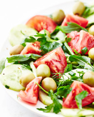 Healthy salad with green olives, tomatoes, cucumber and rocket. 