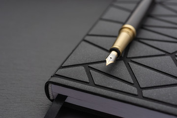 Office table with notepad. fountain pen with black handle.