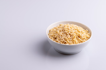 Orzo pasta, isolated on white background. Italian orzo pasta shaped like grains of rice, copy space, soft light