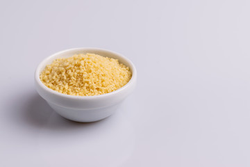 Dry couscous isolated on white background, soft light, copy space.