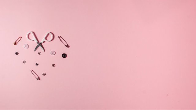 Small sewing set shaped heart on pink background with copy space. Stop motion animation flat lay top view. Design handicraft concept