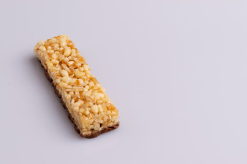 Muesli granola bar with milk chocolate on white background, soft light, copy space