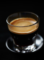Glass of espresso on black background.