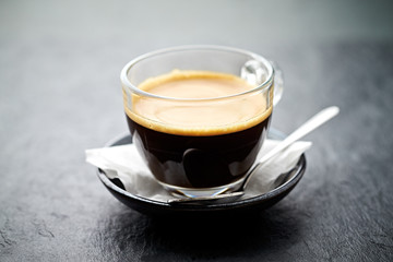 Coffee in glass cup on stone background. Close up. 