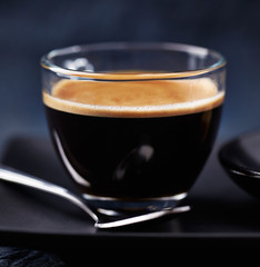 Coffee in glass cup on dark background. Close up. 