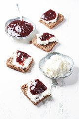 Sandwiches with cream cheese and jam. White wooden background. 