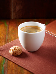 Amaretti (Italian biscuit) and a cup of coffee on dark background. Close up. 