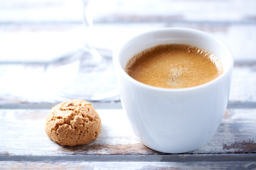 Cup of coffee with amaretti (Italian biscuit) on white wooden background. Close up.