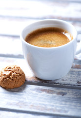 Cup of coffee with amaretti (Italian biscuit) on white wooden background. Close up.