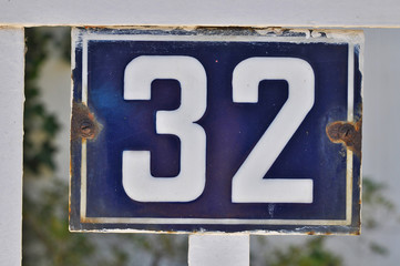 A house number plaque, showing the number thirty two (32)