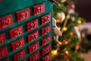 wooden advent calendar in the form of a house under the christmas tree surprise expectation...