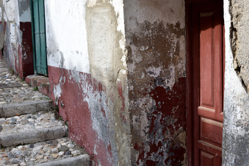 Very damaged house facade with a red and a green door