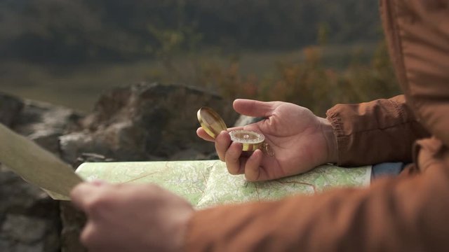 Close up hands of hiker tourist traveler man with compass looking for map route, traveling on mountain, Active lifestyle hiking enjoying vacation travel tourism adventure landscape nature, 4 K slow-mo