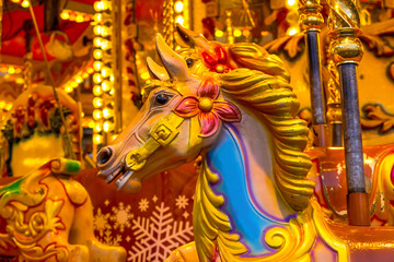 Fototapeta na wymiar Yellow Vintage merry-go-round wooden horses in carusel