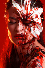 Blood Lily, scary and sexy Halloween image. Beautiful young woman