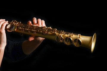 Fototapeta premium soprano saxophone in hands on a black background