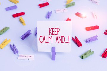 Writing note showing Keep Calm And. Business concept for motivational poster produced by British government Colored clothespin papers empty reminder blue floor officepin