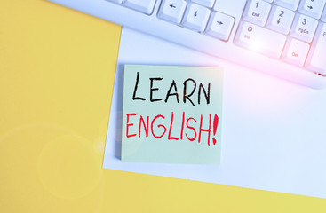 Word writing text Learn English. Business photo showcasing gain acquire knowledge in new language by study Empty blank paper with copy space and pc keyboard above orange background table