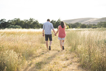Fototapeta na wymiar Couple walking in the dry grass