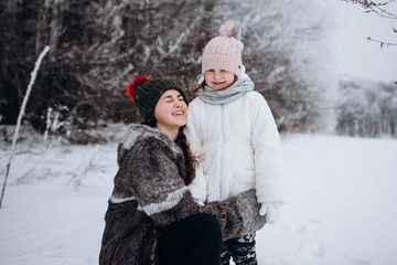 happy family sisters child daughter having fun, playing at winter walk outdoors