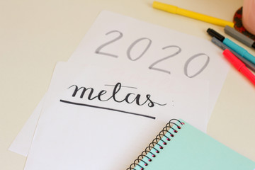 2020 New Year's resolutions handwritten in portuguese "metas" on a sheet of paper on the white table