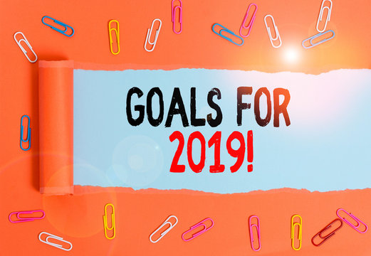Writing note showing Goals For 2019. Business concept for object of demonstratings ambition or effort aim or desired result Paper clip and torn cardboard on wood classic table backdrop