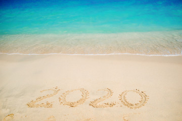 New 2020 year in the South, the sea. Sea surf. Blue wave is coming ashore. Inscription on sand,