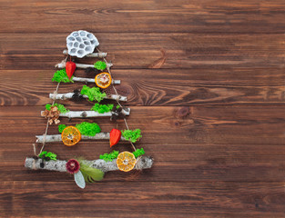 Handmade Christmas tree from natural dried plants on wooden background with copy space