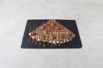 crepe with chocolate sauce and nutella pistachio  on white background