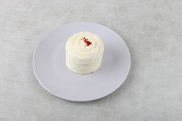 Red velvet cake - vanilla cream cake on a white plate on a texture background 