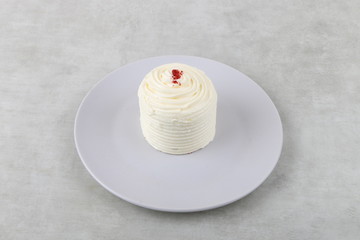 Red velvet cake - vanilla cream cake on a white plate on a texture background 