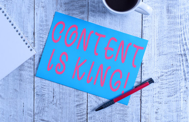Text sign showing Content Is King. Business photo text marketing focused growing visibility non paid search results Stationary placed next to a cup of black coffee above the wooden table