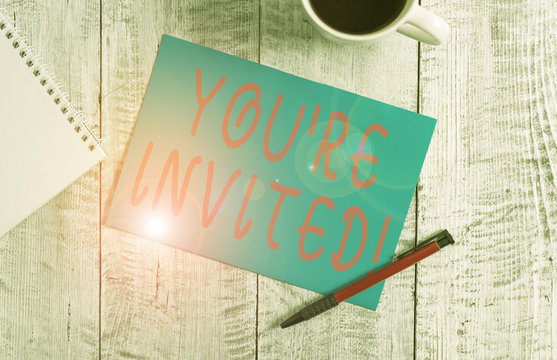 Text sign showing You Re Invited. Business photo text make a polite friendly request to someone go somewhere Stationary placed next to a cup of black coffee above the wooden table