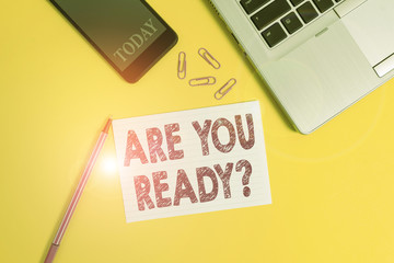 Word writing text Are You Ready Question. Business photo showcasing used telling someone start something when feel prepared Trendy open laptop smartphone marker paper sheet clips colored background