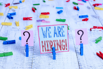 Writing note showing We Are Hiring. Business concept for recently you employ someone or pay someone to do particular job Crumbling sheet with paper clips placed on the wooden table