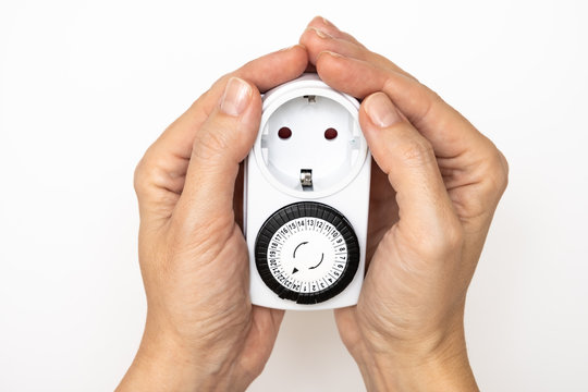 24 Hour 7 days a week mains plug timer switch european socket for energy and money saving in hands on white background