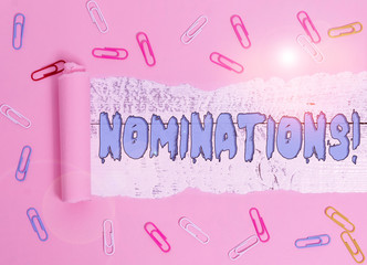 Conceptual hand writing showing Nominations. Concept meaning action of nominating or state being nominated for prize Paper clip and torn cardboard on wood classic table backdrop