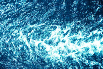 Blue ocean water with ripples and foam texture