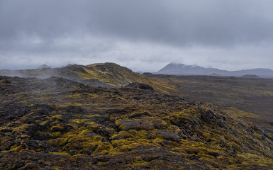 Leirhnjukur old black lava field and smoke in Iceland, overcast. Cloudy day in September 2019