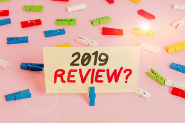Conceptual hand writing showing 2019 Review Question. Concept meaning remembering past year events main actions or good shows Colored clothespin papers empty reminder pink floor office