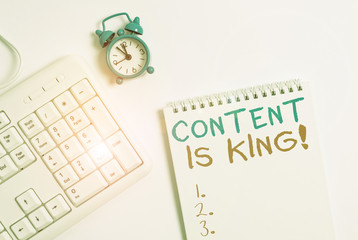 Writing note showing Content Is King. Business concept for marketing focused growing visibility non paid search results Keyboard with empty note paper and pencil white background