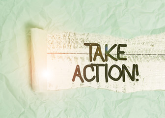 Text sign showing Take Action. Business photo text do something official or concerted to achieve aim with problem Cardboard which is torn in the middle placed above a wooden classic table