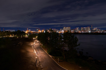 Fototapeta premium walkway in odaiba park at night with harbour and cityscape light of tokyo