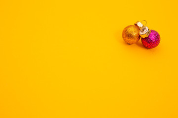 Copper and pink Christmas baubles on orange background, with copyspace