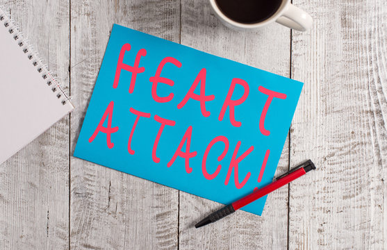 Text sign showing Heart Attack. Business photo text sudden occurrence of coronary thrombosis resulting in death Stationary placed next to a cup of black coffee above the wooden table