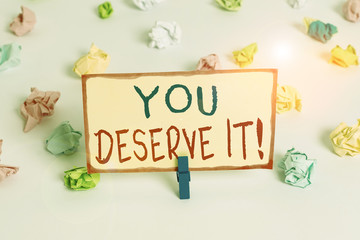 Handwriting text You Deserve It. Conceptual photo should have it because of their qualities or actions Colored crumpled papers empty reminder white floor background clothespin