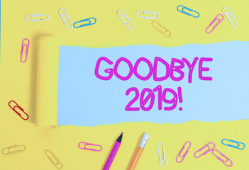 Text sign showing Goodbye 2019. Business photo showcasing express good wishes when parting or at the end of last year Stationary and torn cardboard placed above a plain pastel table backdrop
