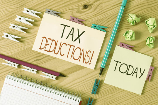 Word writing text Tax Deductions. Business photo showcasing reduction income that is able to be taxed of expenses Colored clothespin papers empty reminder wooden floor background office